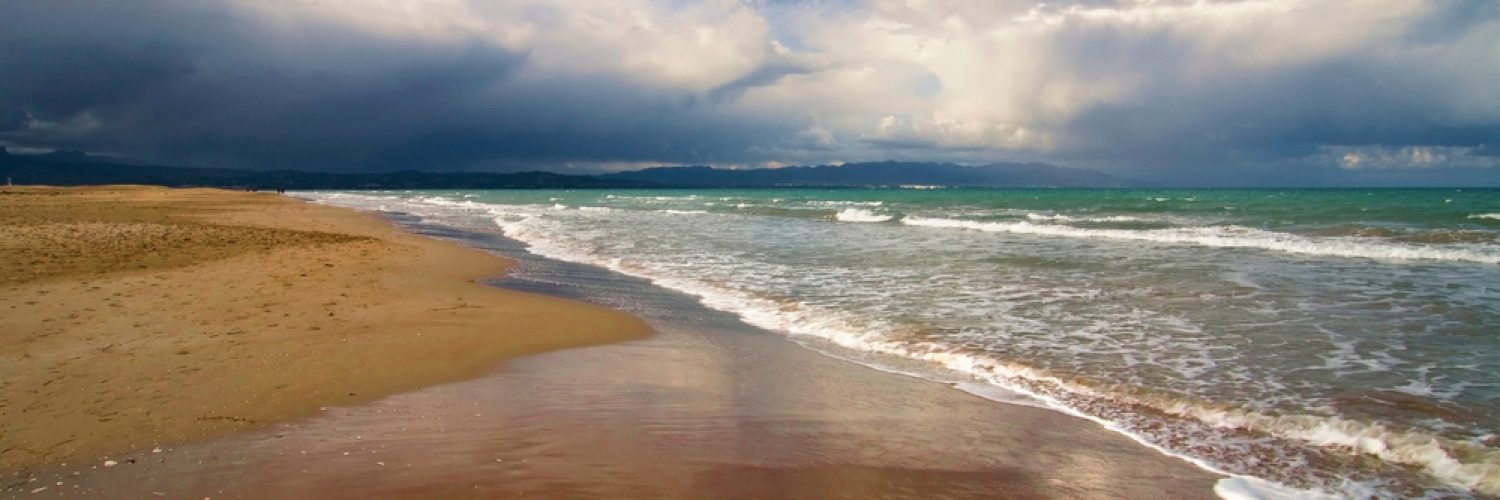 Storm clouds approaching a deserted beach.