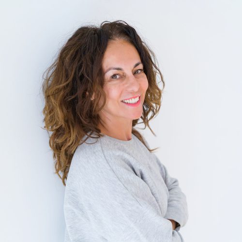 Beautiful middle age woman with curly hair smiling cheerful and happy with arms crossed, laughing with a big smile on face showing teeth over white isolated background