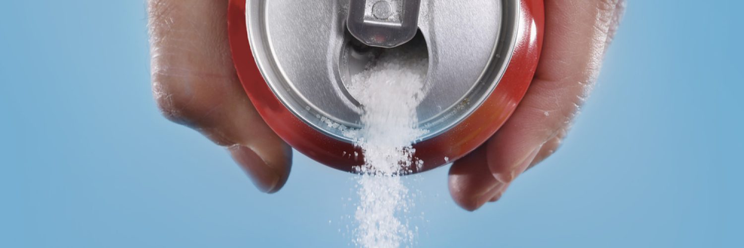 hand holding soda can pouring a crazy amount of sugar in metaphor of sugar content of a refresh drink isolated on blue background in healthy nutrition, diet and sweet addiction concept