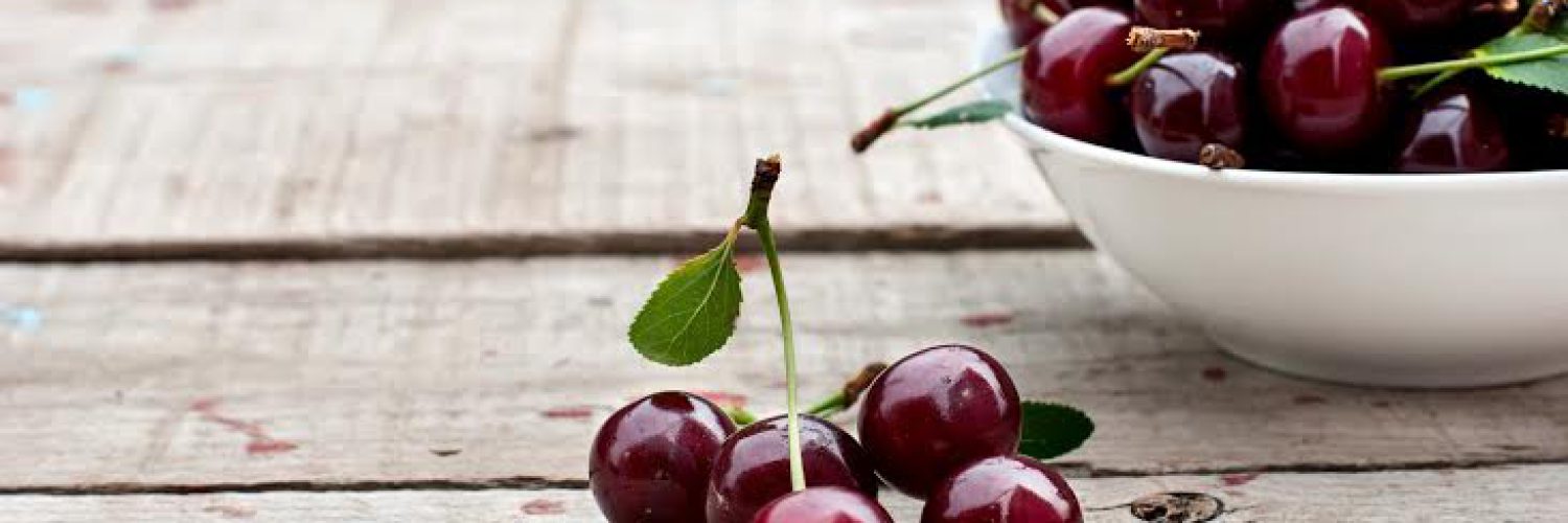 ripe juicy cherries lie in bulk on a wooden background